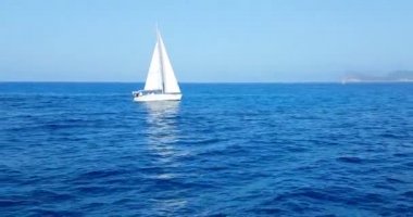 Gün ışığında güzel bir sahil, sakin bir deniz, yazın çok popüler, kumlu sahil, ibiza gemilerinin muhteşem bir manzarası var.