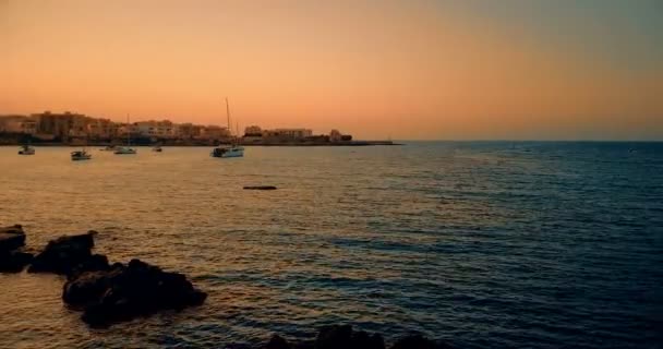 Piękna plaża o zachodzie słońca z spokojnym morzem, w lecie bardzo popularne, piaszczyste wybrzeże mają fantastyczny widok na wyspę Ibiza. Zacumowany — Wideo stockowe