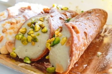 Tipik Sicilya Cannoli 'si tepside, ricotta ve şam fıstığı tanelerinden yapılmış lezzetli İtalyan yemekleri.