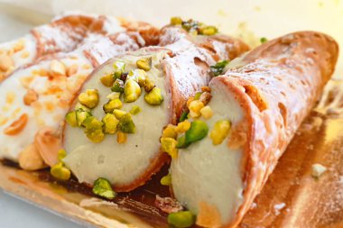 Tipik Sicilya Cannoli 'si tepside, ricotta ve şam fıstığı tanelerinden yapılmış lezzetli İtalyan yemekleri.