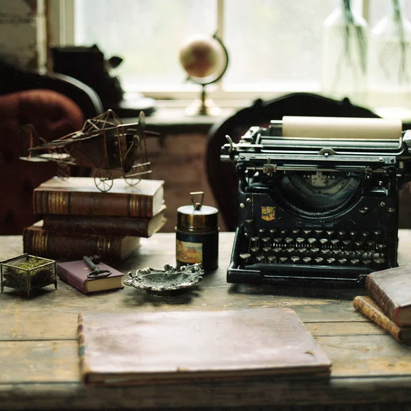 Books with typing machine on table — Stock Photo, Image