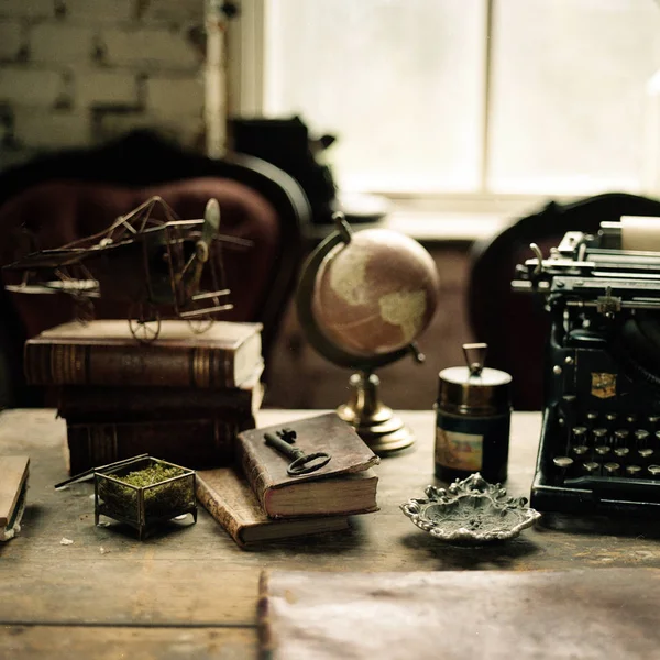 Böcker med Globen och skriva maskin på bord — Stockfoto