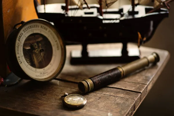 Spyglass, barometer and  wooden ship — Stock Photo, Image