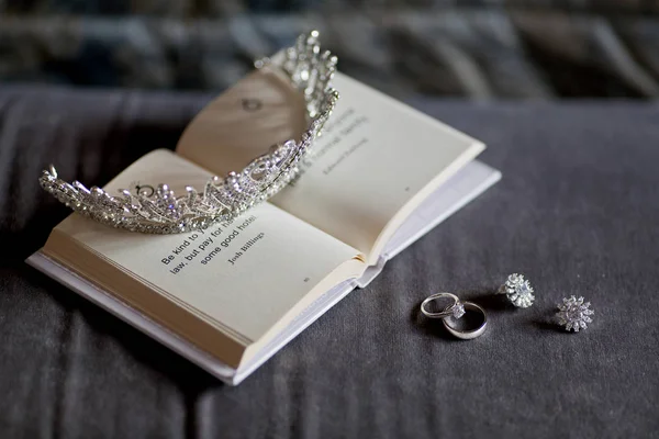 stock image diadem on book with rings and earrings