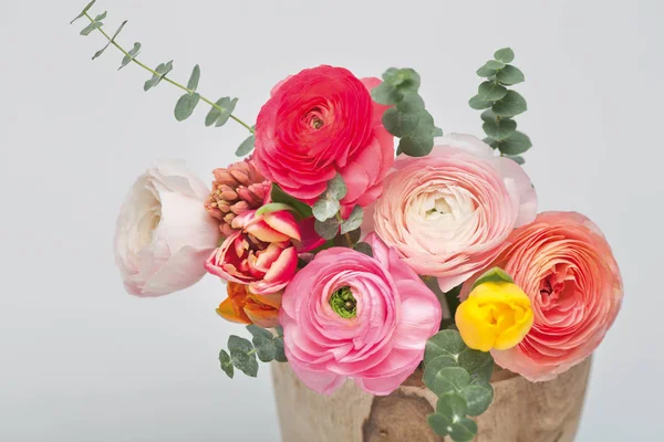 closeup view of cut flowers in pot on white background