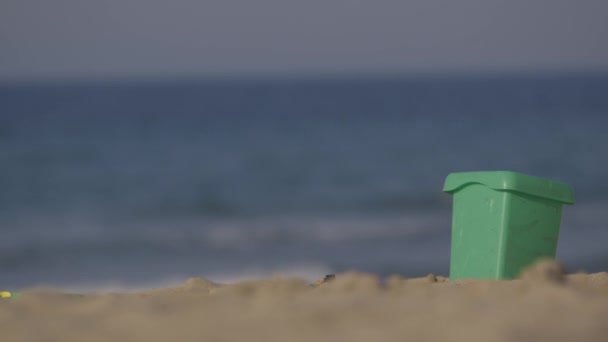 Wiadro z tworzywa sztucznego na piaszczystej plaży — Wideo stockowe