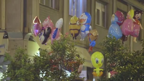 Verschiedene Luftballons Die Comic Helden Auf Der Straße Gegen Gebäude — Stockvideo
