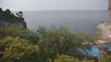 Ischia Adası yeşil çalılar ve ağaçlar havuz ve plaj yatak ile uzak gündüz görünümü