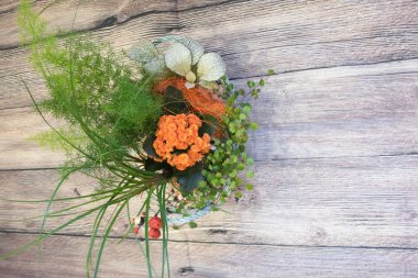turuncu çiçekler ve yeşil yaprakları ve hediye olarak sepette başka bir bitki ile Kalanchoe ile ikebana