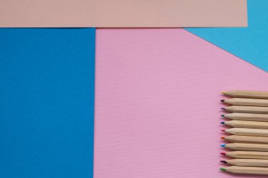 Mavi ve pembe renkli arka planda yakın plan mavi ve pembe kalem. asgari kavram