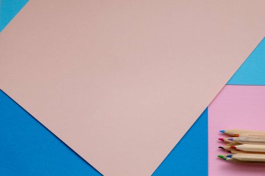 Renkli kalemlerle renklendirilmiş pembe ve mavi renkli kâğıt arkaplanlı çok renkli kalemler. Siyah arka planda renkli kalemler yığını. Kavram: Hayata boş bir sayfa ile başla.