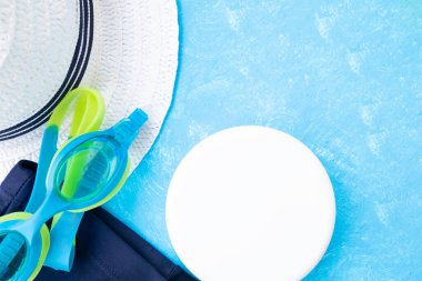 Yaz aksesuarları. Mavi desenli arka planda gözlük, yüzme şortu ve diğerleri. Üst görünüm ve kopyalama alanı