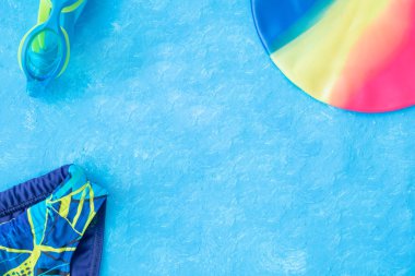 Mavi desenli arka planda havuzda yüzmek için aksesuarlar.