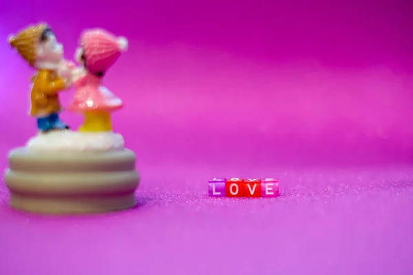 Walentynki twórcza karta zakochanej pary na liliowym tle z napisem miłość. — Zdjęcie stockowe