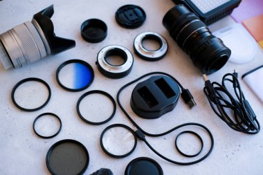 Gri arka planda profesyonel fotoğrafçı için ekipman içeren düz konum.