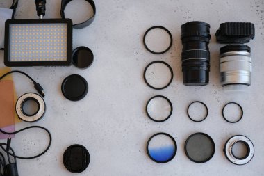 Gri arka planda profesyonel fotoğrafçı için ekipman içeren düz konum