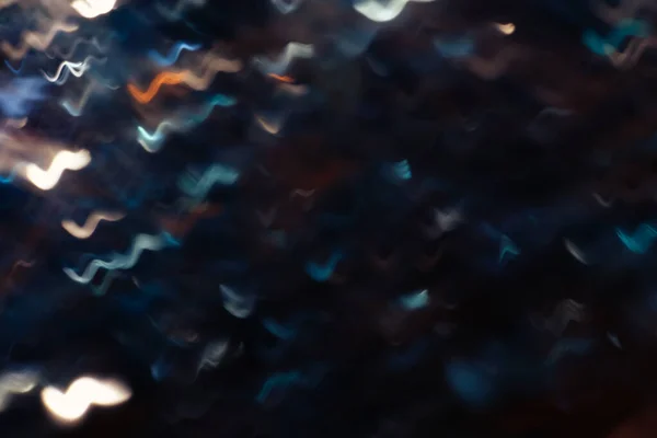 Siyah arka planda koyu mavi Bokeh parıltısı. Renk arkaplanının ışıkları. Farklı renkteki ışıkların yönünü değiştir. Soyut parlak mavi renkli bokeh.