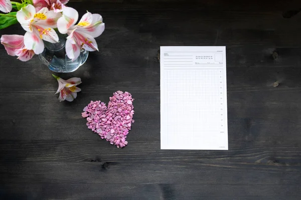 Плоский календарь с розовым сердцем и планирование на темном деревянном фоне — стоковое фото