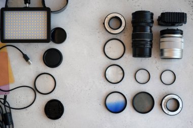 Gri arka planda profesyonel fotoğrafçı için ekipman içeren düz konum