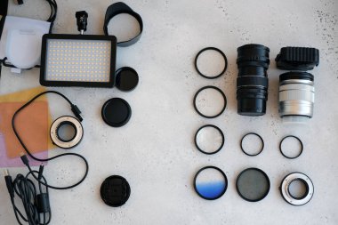 Gri arka planda profesyonel fotoğrafçı için ekipman içeren düz konum