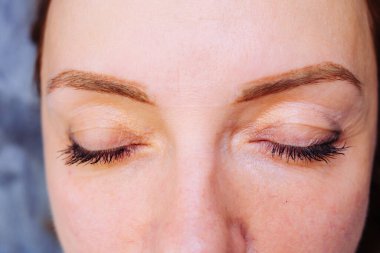 Güzellik portresi, kaşlara odaklanmış, dövme spreyleme tekniğinde. Kaşlarında kalıcı makyaj dövmesi var..