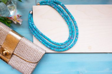 Çiçeklerle, boncuklarla, kadın debriyajıyla, küçük bir yaz çantası. Kadınların Düz Yatağı. Metnin için boşluk olan üst görünüm .