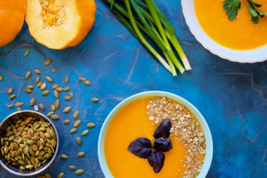 . Top View, ayçiçeği tohumları ve yeşil soğan, mavi arkaplanda servis kasesinde mor fesleğen. Mavi arka planda mor fesleğenli balkabağı çorbası.