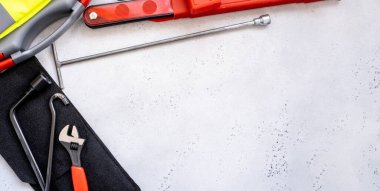 Banner araba acil durum kiti - uyarı üçgeni tehlike işareti, ilk yardım çantası ve yansıtıcı yelek, kriko cihazının metal kanca parçası, ingiliz anahtarı ve altıgen konsept araba bakımı, kaza önleme.