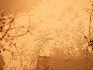 Kış, donmuş camların ardından soyut arkaplan renginde mercanlar. Camın üzerindeki soğuk hava deseni. Buz tutmuş pencerenin soyut arkaplanı. Kış günü, güneş penceredeki buzlu camdan parlıyor..