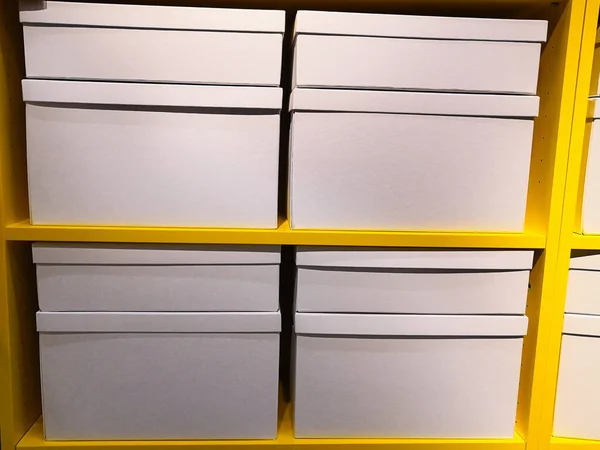 the boxes are white on yellow metal shelves. concept system storage of household items