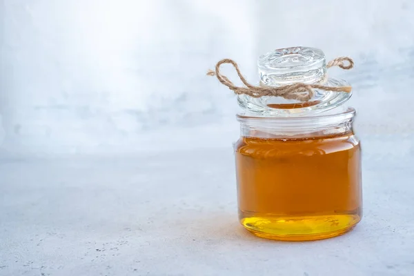 Banner fresh honey on a glass container. Following center dominant law in white paper background. The concept of honey for sale