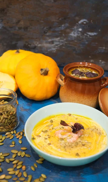 Tasty pumpkin cream soup with shrimps and basil leaves, blended with spice and carrots. Top view. — Stock Image Tasty Pumpkin Cream Soup Shrimps Basil Leaves Blended Spice Carrots Royalty Free Stock Images