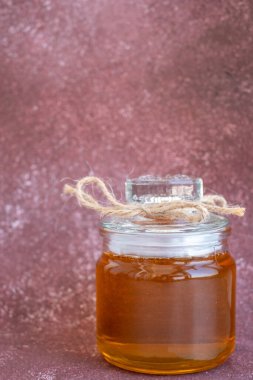 Kestane rengi arka planda taze bal olan kompozisyon. Beyaz kağıt arka planında merkezi baskın hukuku takip ediyorum. Satılık bal konsepti