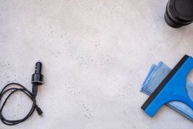 Silecek bıçağı, cam kazıyıcı, mikrofiber bez ve bir de çakmağın şarj aleti. Cam Kazıma Aracı veya Gri arka planda Duş, Pencere ve Araba Camları için Squeegee