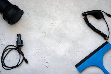 Silecek bıçağı, cam kazıyıcı, mikrofiber bez ve bir de çakmağın şarj aleti. Cam Kazıma Aracı veya Gri arka planda Duş, Pencere ve Araba Camları için Squeegee