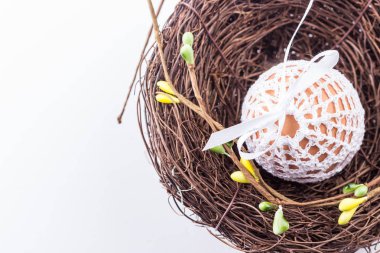 Paskalya yortusu yumurta yuva, Bahar dekor ile el yapımı örgü beyaz çantaya. Seçici odak.