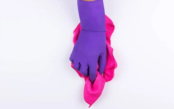 Рука в фиолетовой резиновой перчатке с розовой тканью — стоковое фото