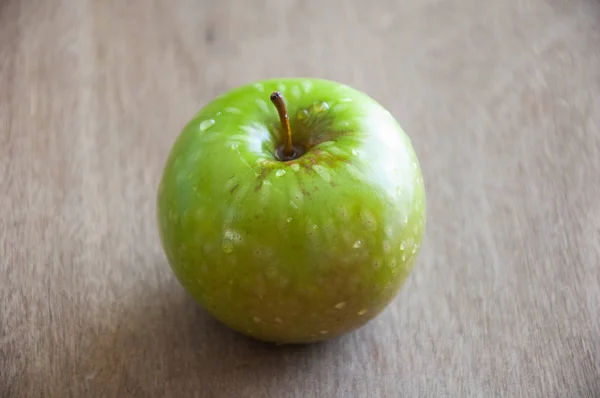木制底座上的绿色苹果. — 图库照片