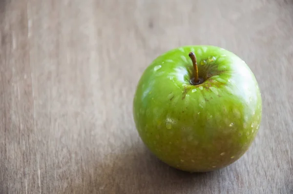 木制底座上的绿色苹果. — 图库照片