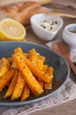 Aperatif. Bir tabakta krema sosu ile baharat içinde pişmiş kabak parçaları.