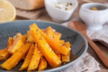 Aperatif. Bir tabakta krema sosu ile baharat içinde pişmiş kabak parçaları.