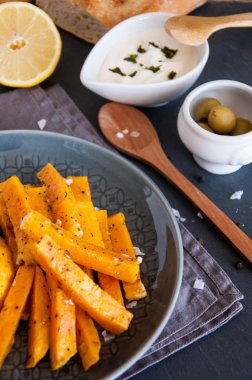 Aperatif. Bir tabakta krema sosu ile baharat içinde pişmiş kabak parçaları.