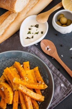 Aperatif. Bir tabakta krema sosu ile baharat içinde pişmiş kabak parçaları.