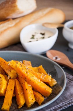 Aperatif. Bir tabakta krema sosu ile baharat içinde pişmiş kabak parçaları.