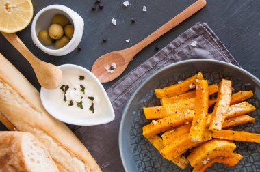 Aperatif. Bir tabakta krema sosu ile baharat içinde pişmiş kabak parçaları.