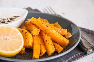 Aperatif. Bir tabakta krema sosu ile baharat içinde pişmiş kabak parçaları.