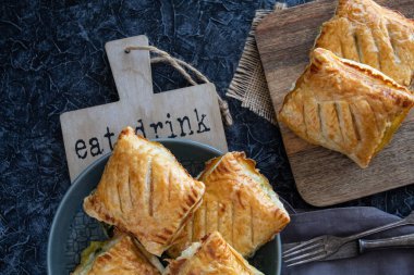 Gri arka planda ıspanaklı taze poğaça çörekleri.