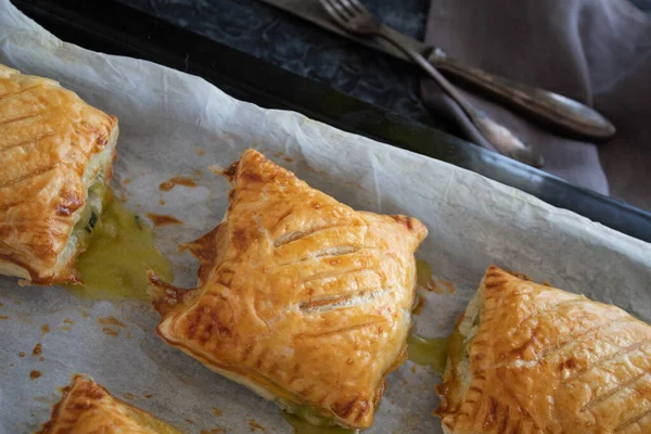 Gri arka planda ıspanaklı taze poğaça çörekleri.