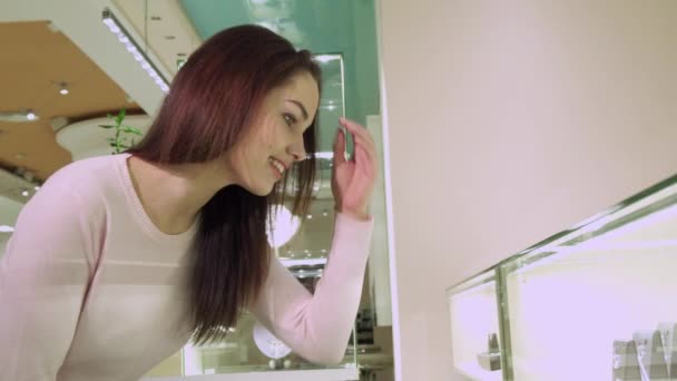 Menina toca seu cabelo na loja de jóias — Vídeo de Stock