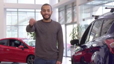 Adam arabanın anahtarını elinde tutuyor.